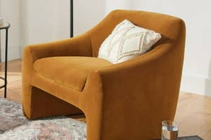 Plush armchair with a textured throw pillow in a living room setting