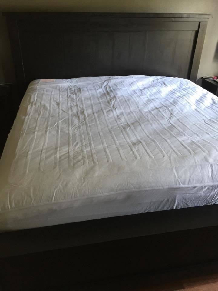 A neatly made bed with a heated mattress pad