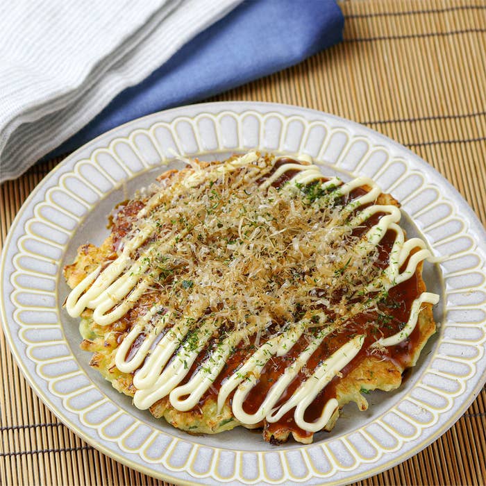 皿に盛られたお好み焼き、ソースとマヨネーズ、かつお節がトッピング。