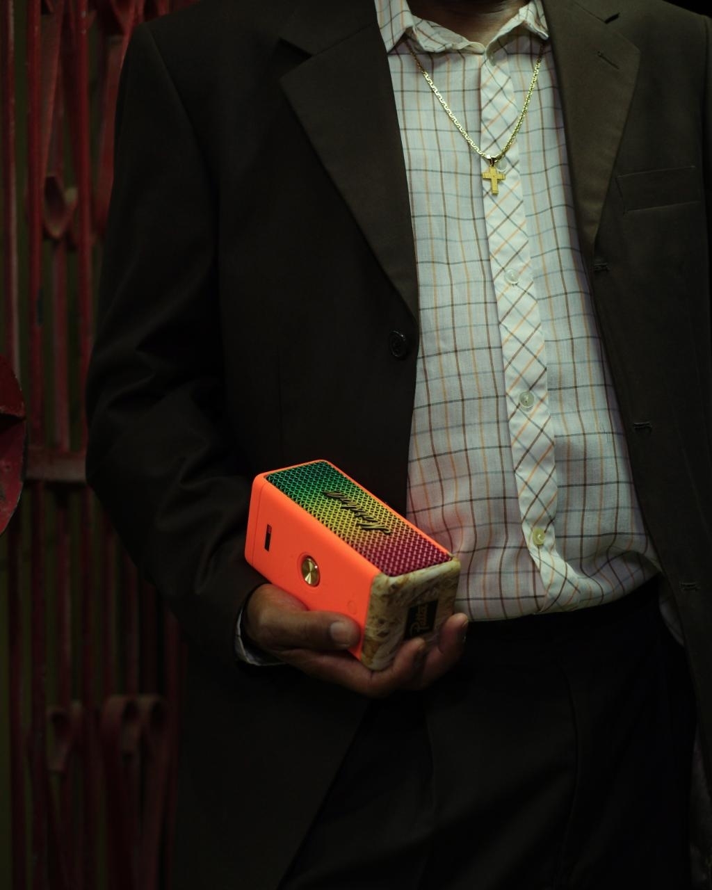 Person in a suit holding a small, colorful object. Details or identity unknown