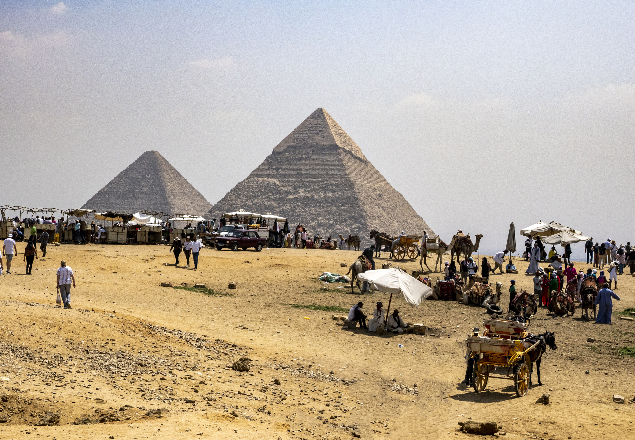 The Great Pyramids of Giza with tourists and camel rides in the foreground