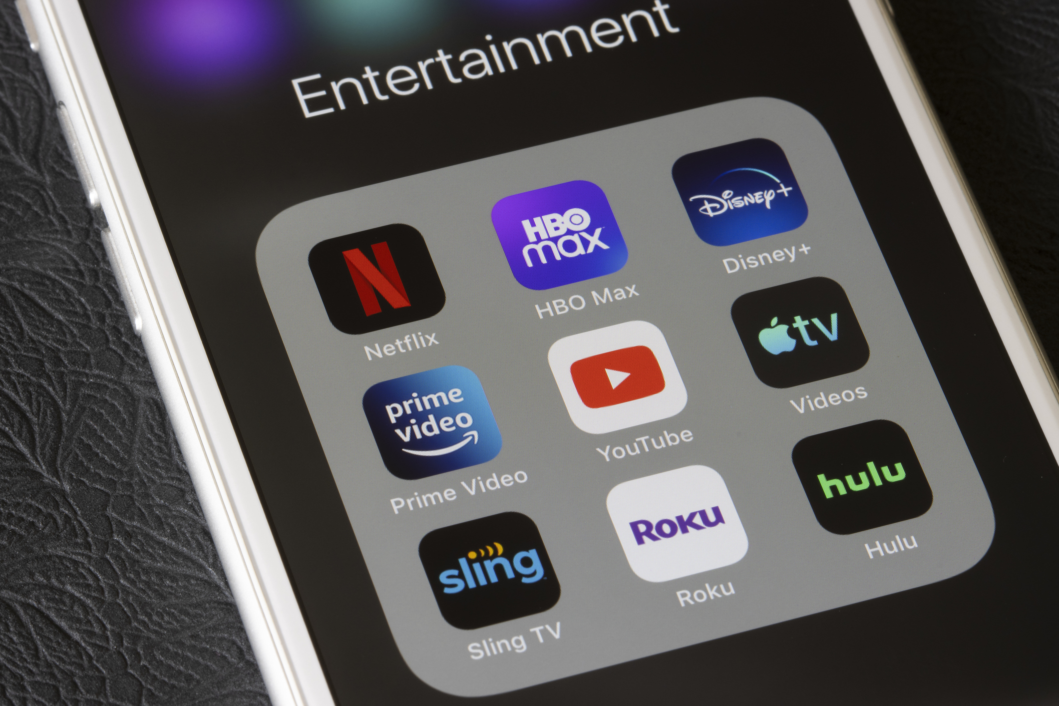 Close-up of a smartphone screen showing entertainment app icons like Netflix, HBO Max, Disney+, and others