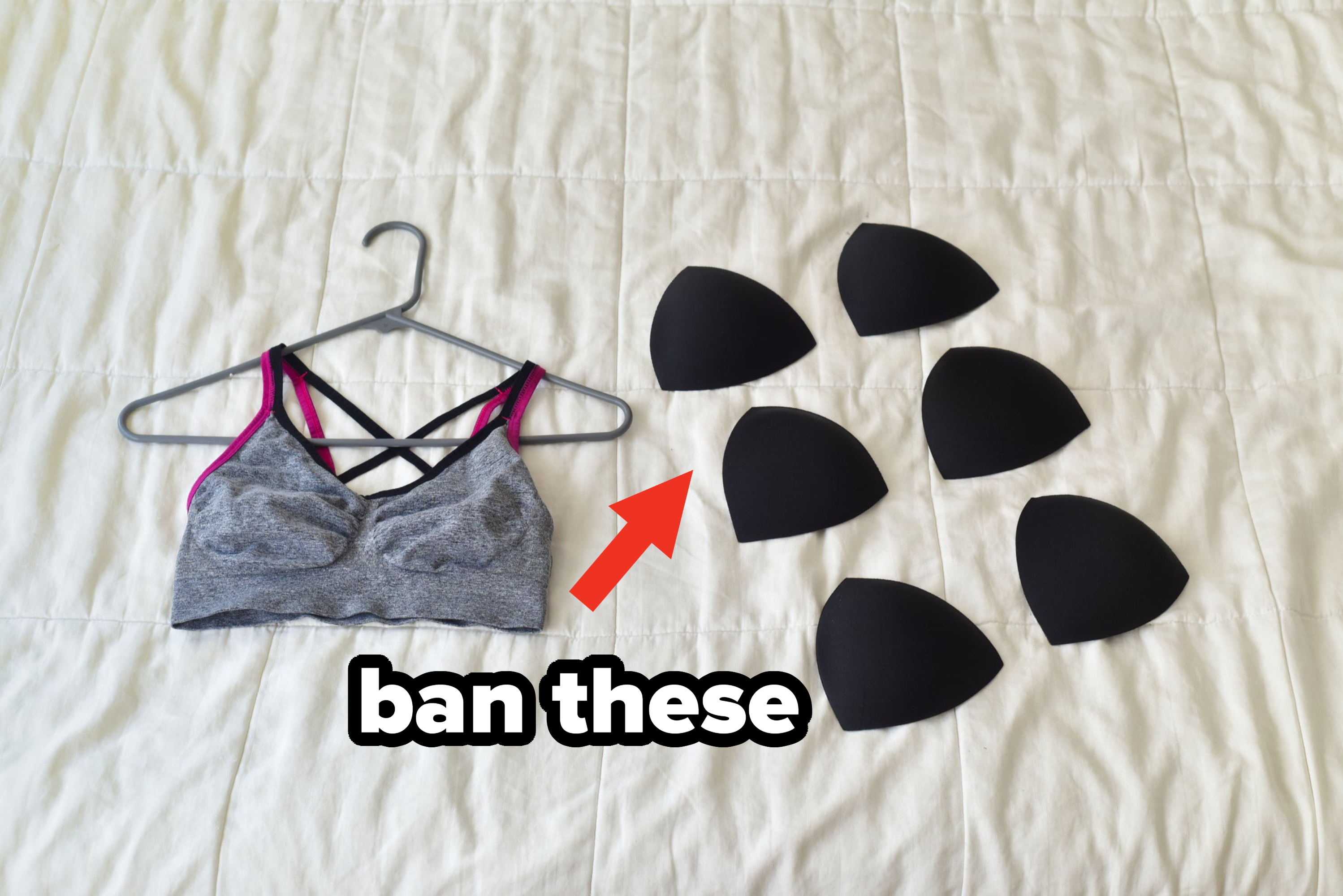 Sports bra on a hanger next to various bra cup inserts on a quilted background