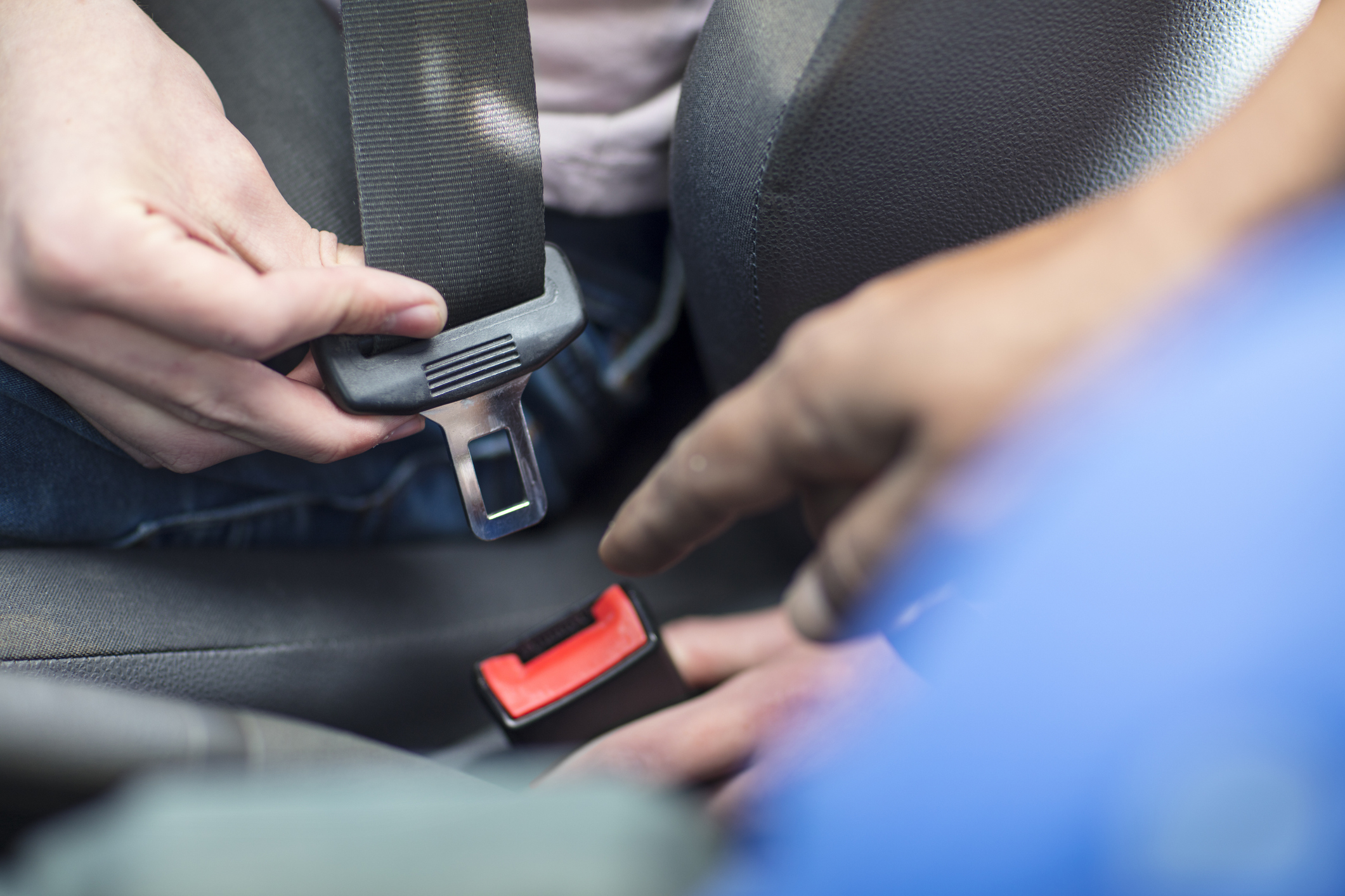 Person fastening a seatbelt in a vehicle