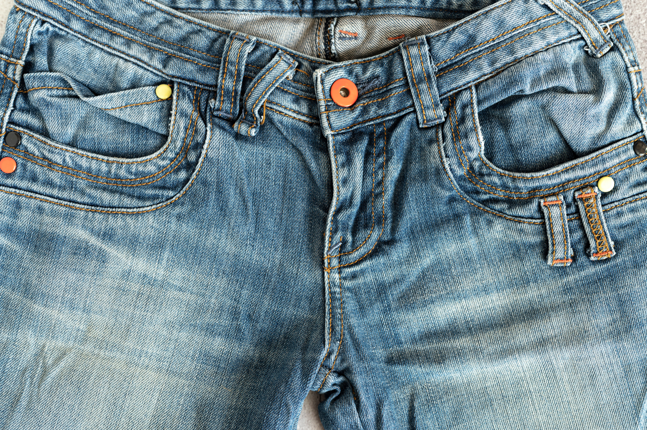 Close-up of a pair of denim jeans with button and pockets visible