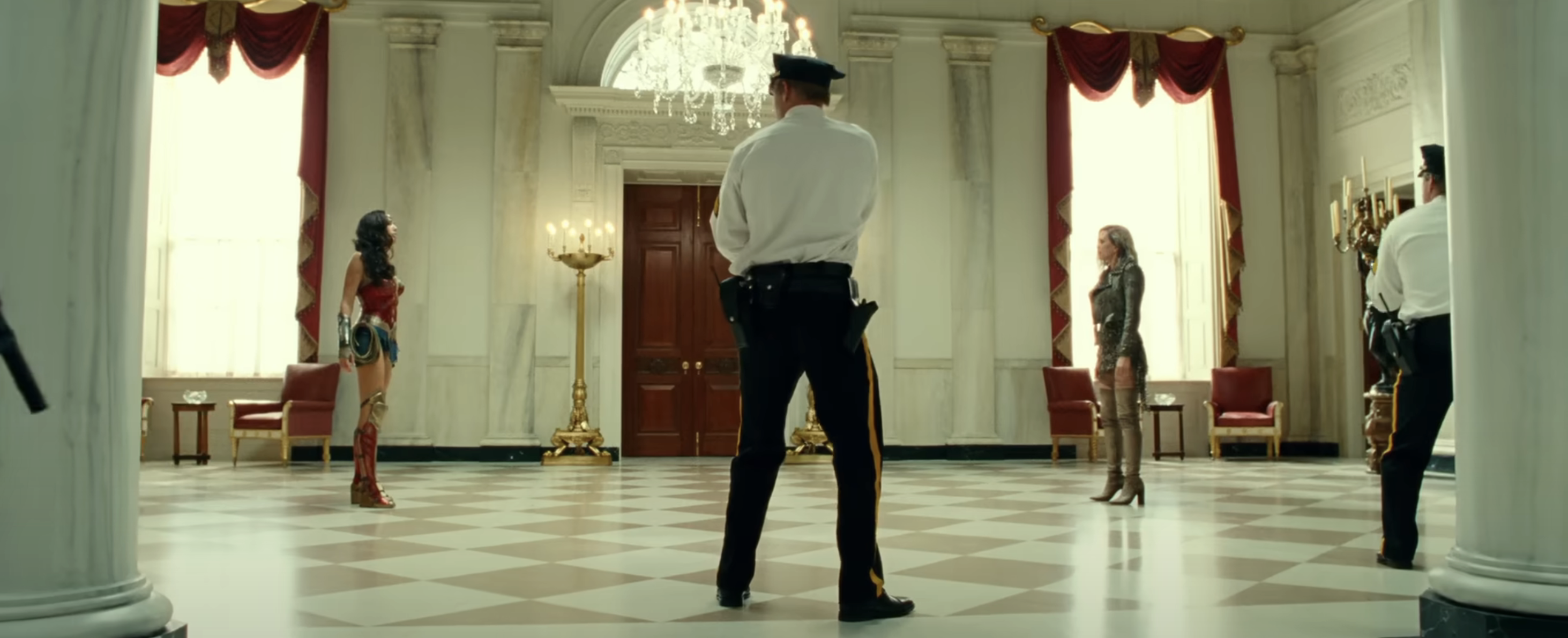 Wonder Woman stands in a poised stance facing Cheetah in an opulent room, a policeman observes