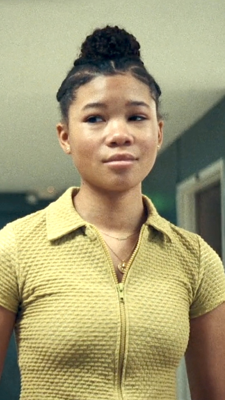 Young woman in a collared shirt, portraying a character in a scene