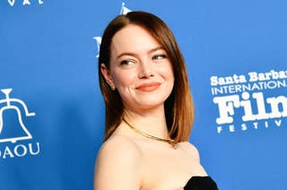 Emma Stone poses in a black dress with gold accents at the Santa Barbara International Film Festival