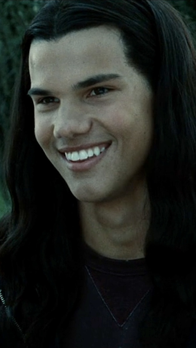 Jacob Black from Twilight smiles in a close-up shot; he wears a dark crewneck shirt