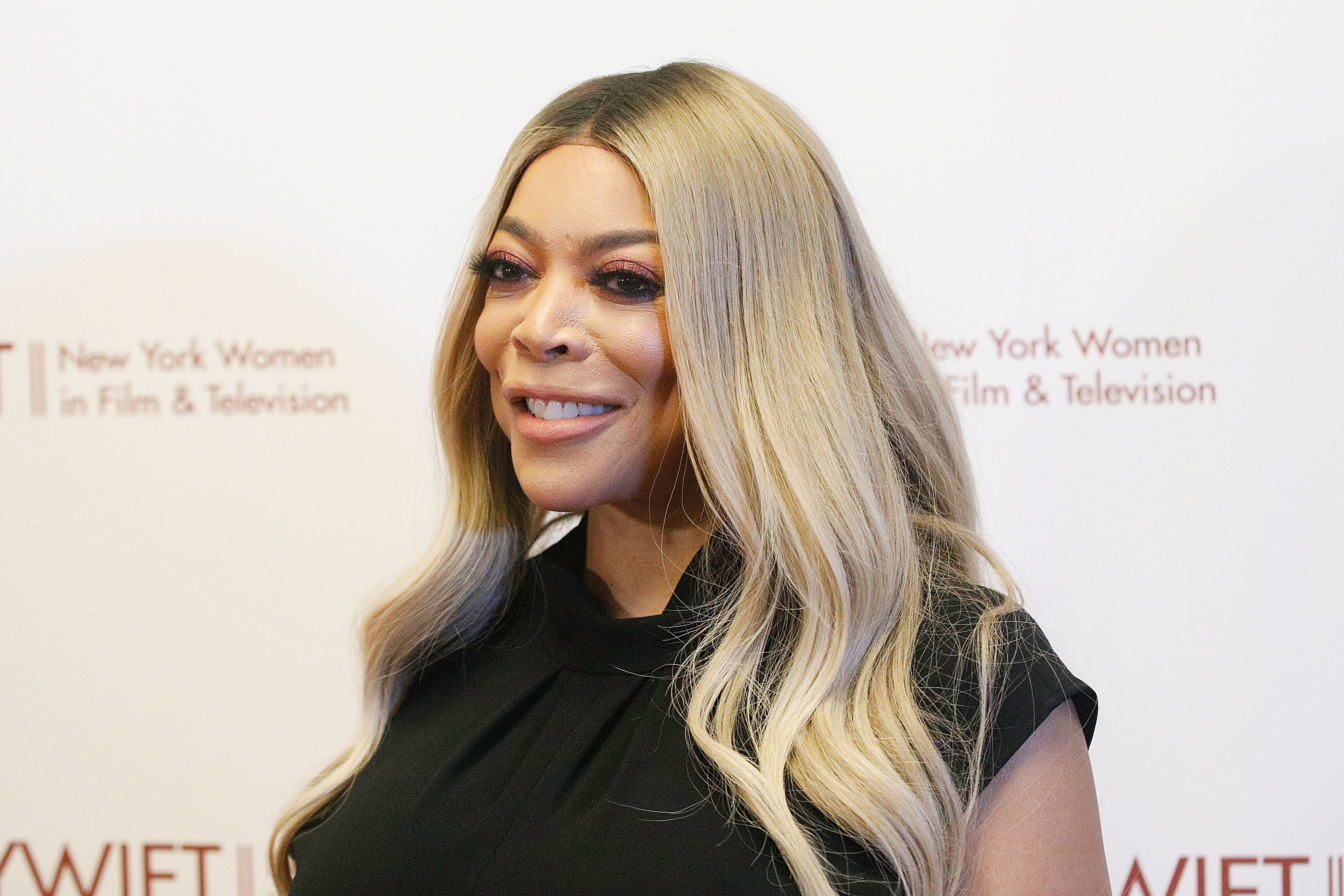 Wendy Williams smiling at a New York Women in Film &amp; Television event, short-sleeved black dress