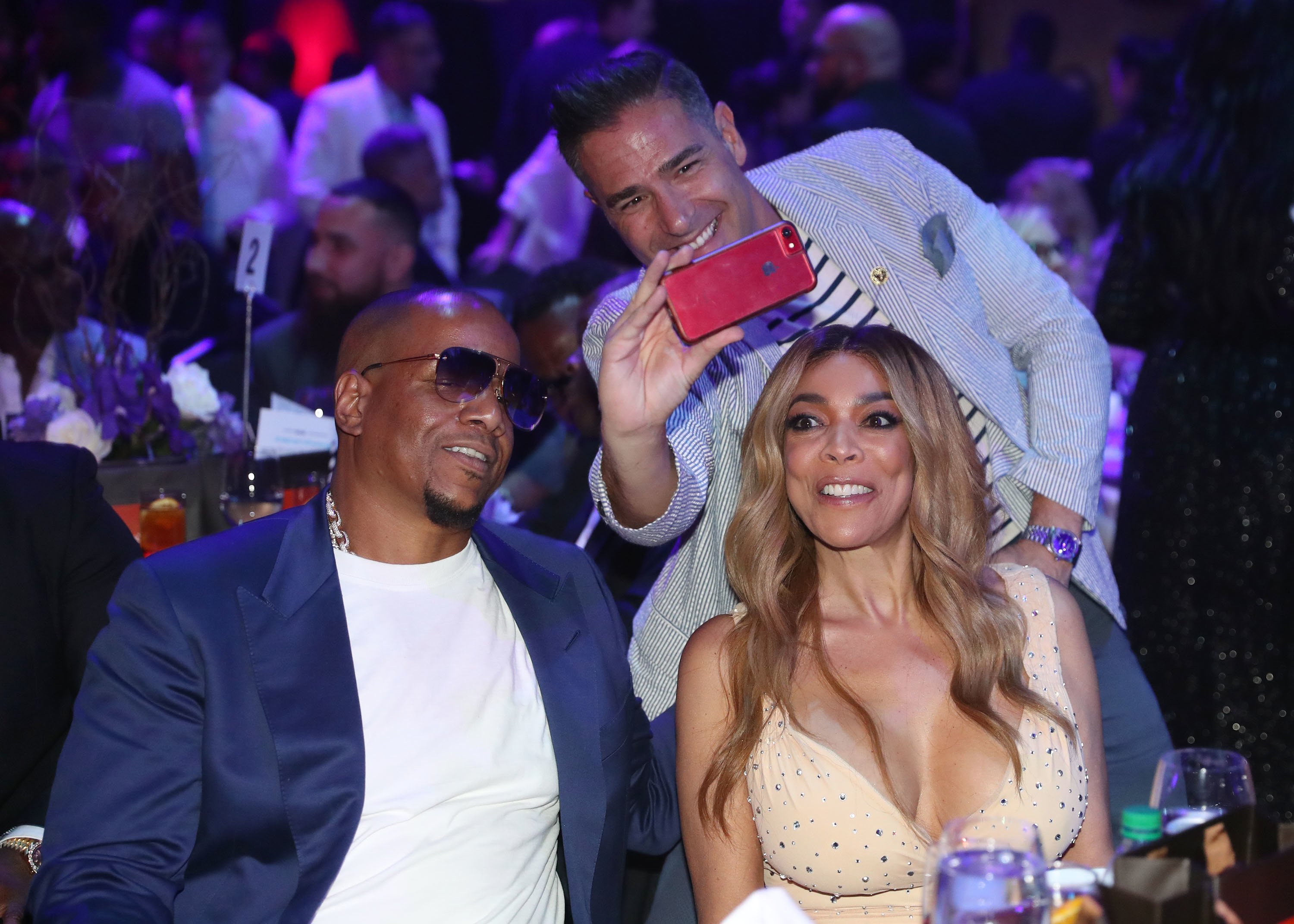 Wendy Williams and guests smiling and taking a selfie at a social event