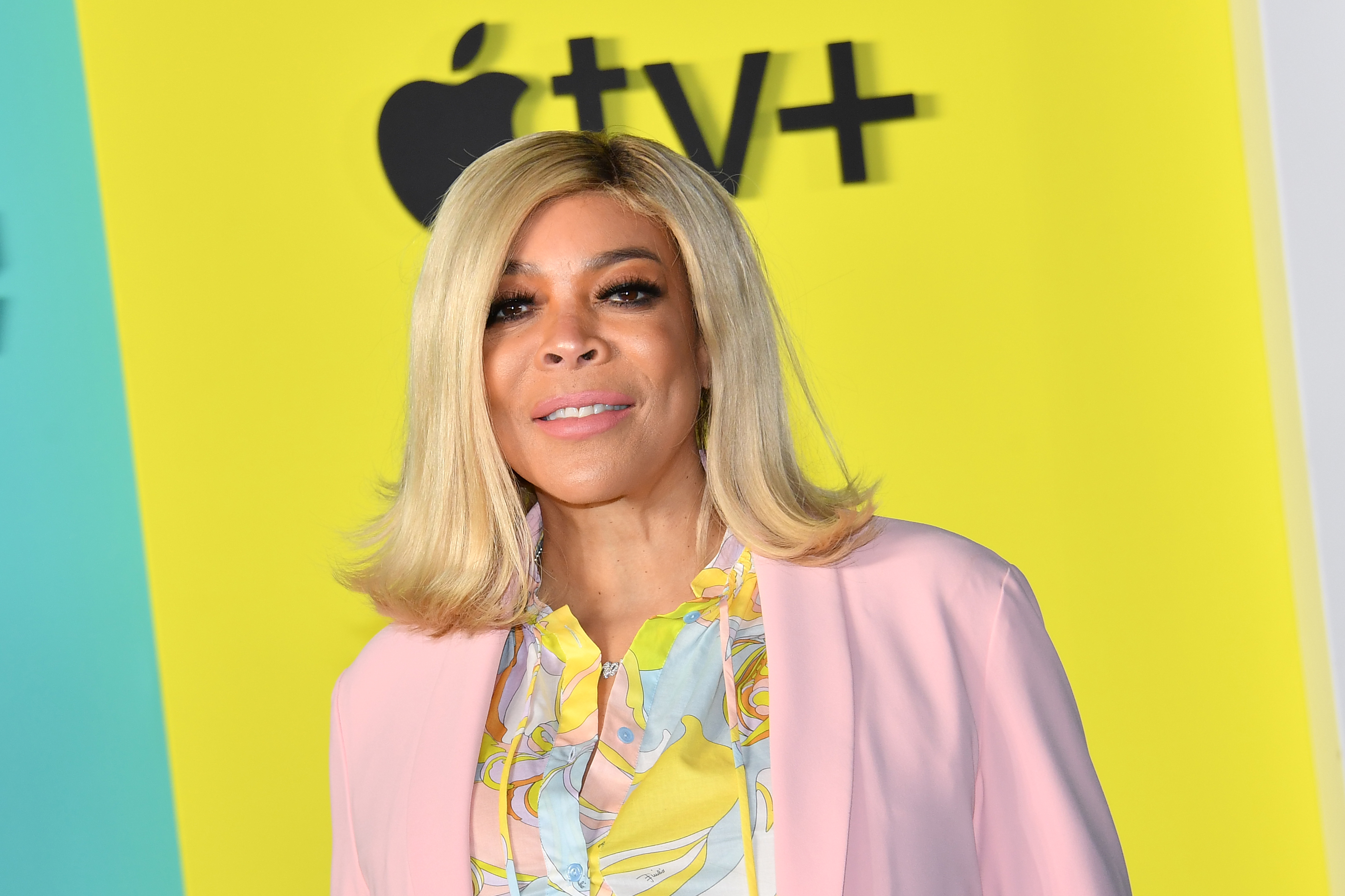 Wendy Williams posing in a pastel blazer over a patterned blouse