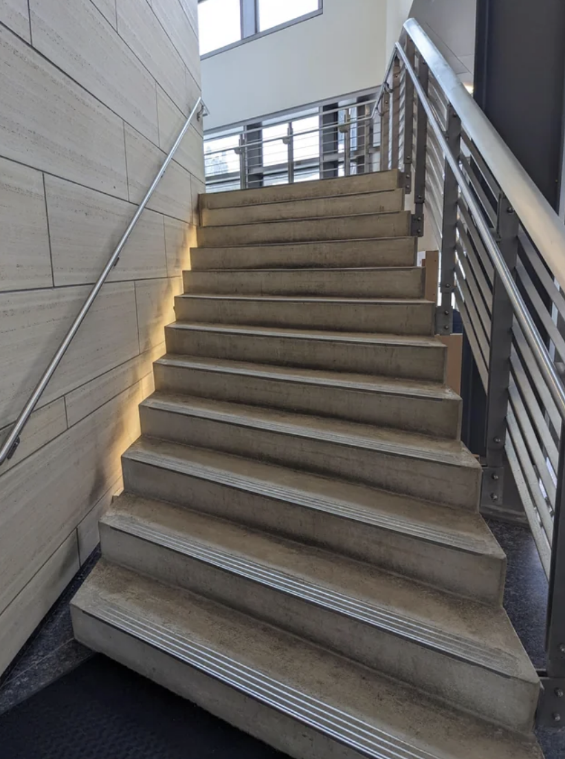 A staircase with metal handrails on both sides leading upwards