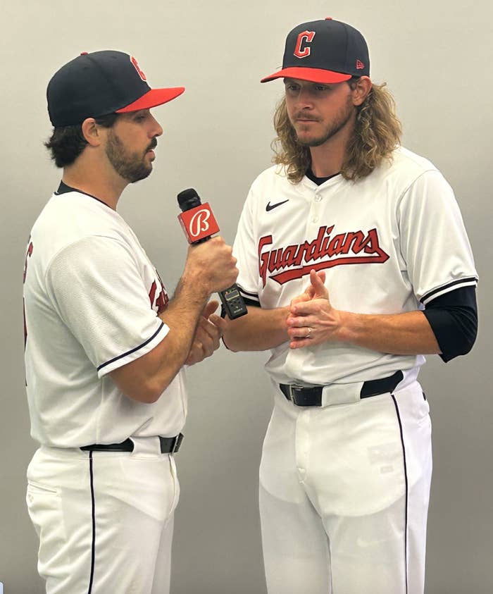 Two baseball players in Cleveland Guardians uniforms engage in an interview