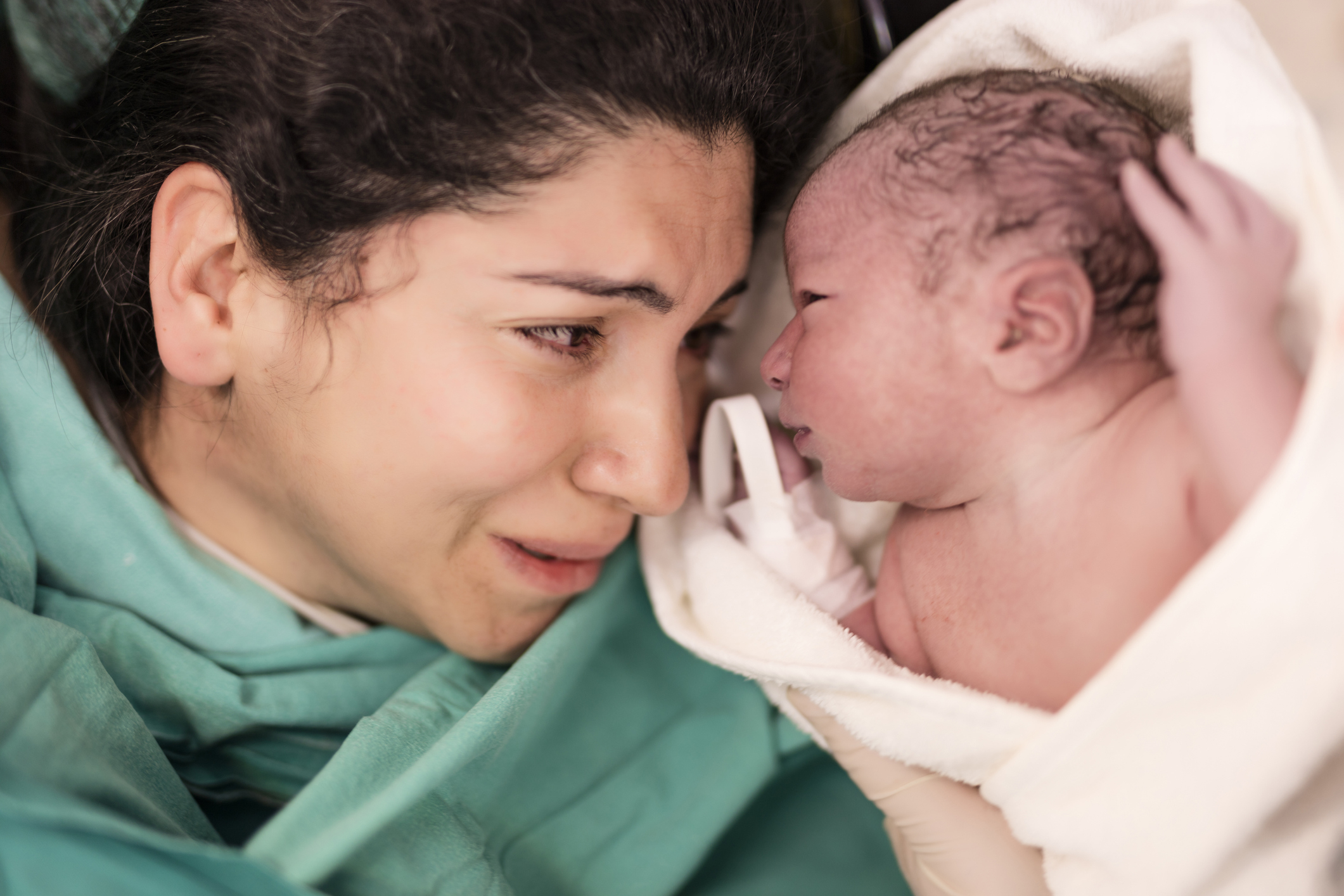 Woman holding and gazing affectionately at her newborn baby