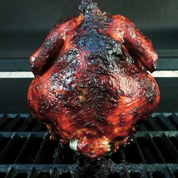 Roasted chicken on a grill, with crispy skin, cooked to a juicy finish. No persons in image
