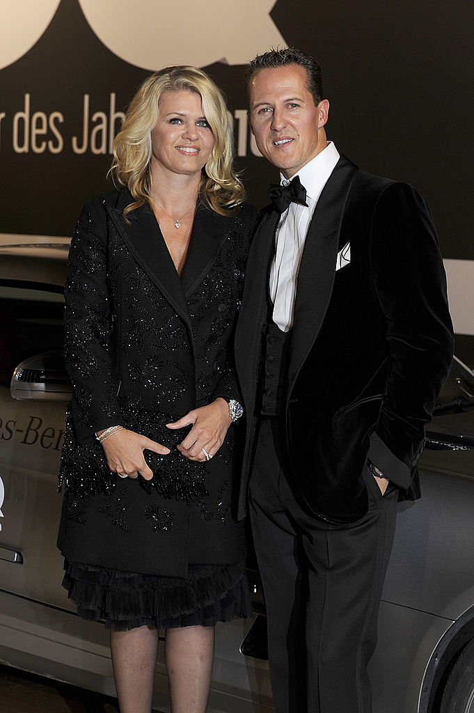 Corinna and Michael standing side by side in evening attire standing by a car