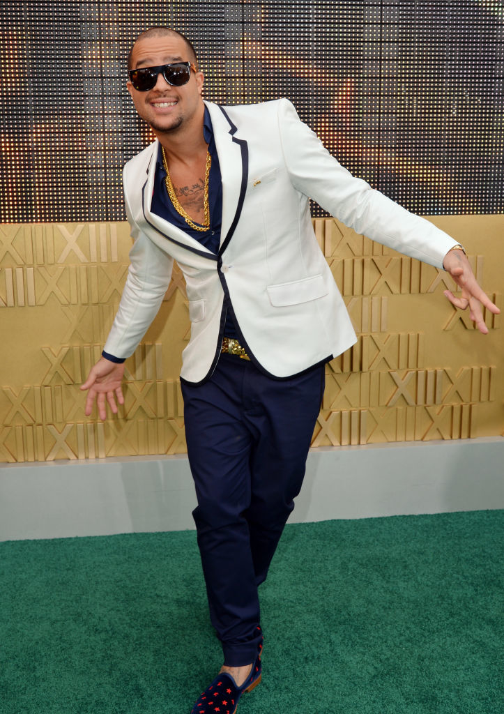 Sky Blue in a blazer and trousers posing playfully on a red carpet