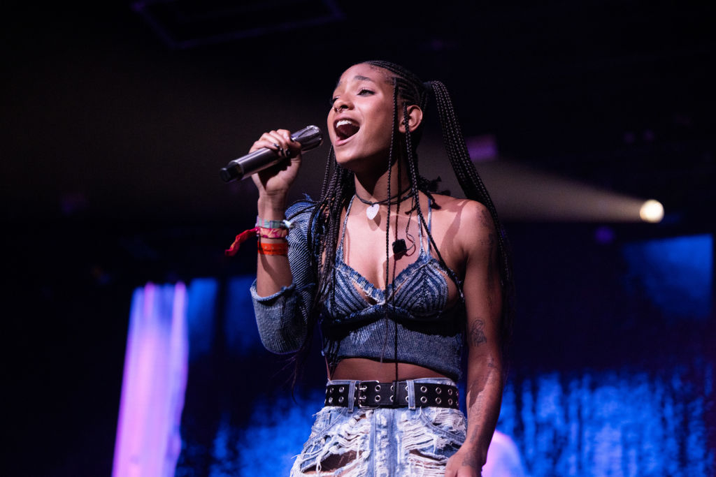 Willow Smith performs on stage in a denim corset top and metallic pants