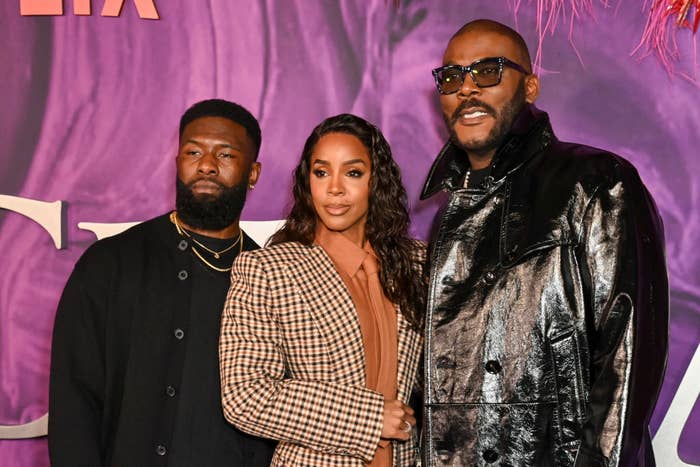 From left right: Trevante Rhodes, Kelly Rowland, and Tyler Perry posing together, the center figure in a checkered outfit, flanked by one in black and another in a shiny jacket