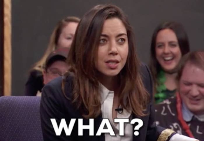 Aubrey Plaza with a surprised expression and the word &quot;WHAT?&quot; in bold text superimposed