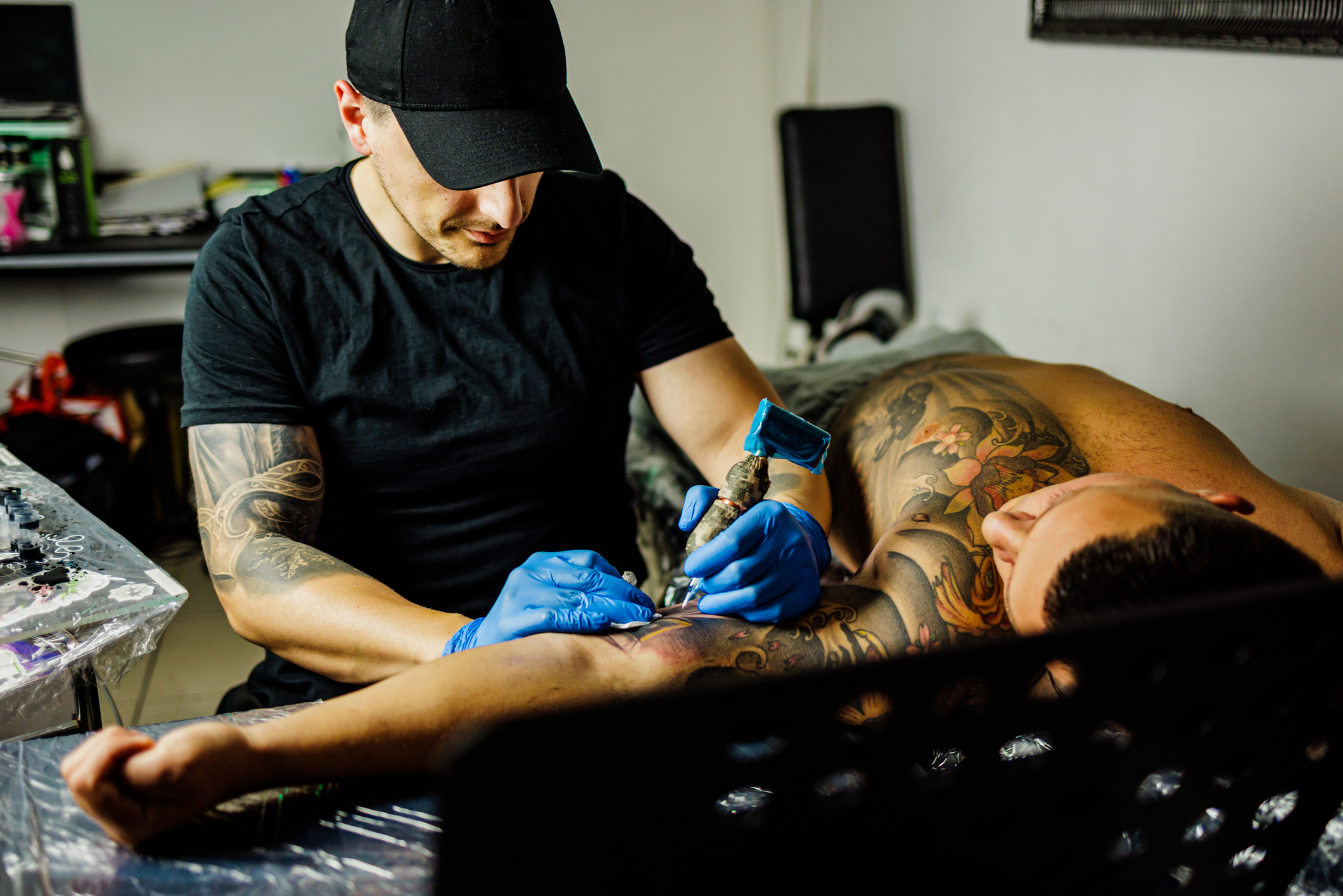 Tattoo artist working on a client&#x27;s arm both are focused on the tattooing process
