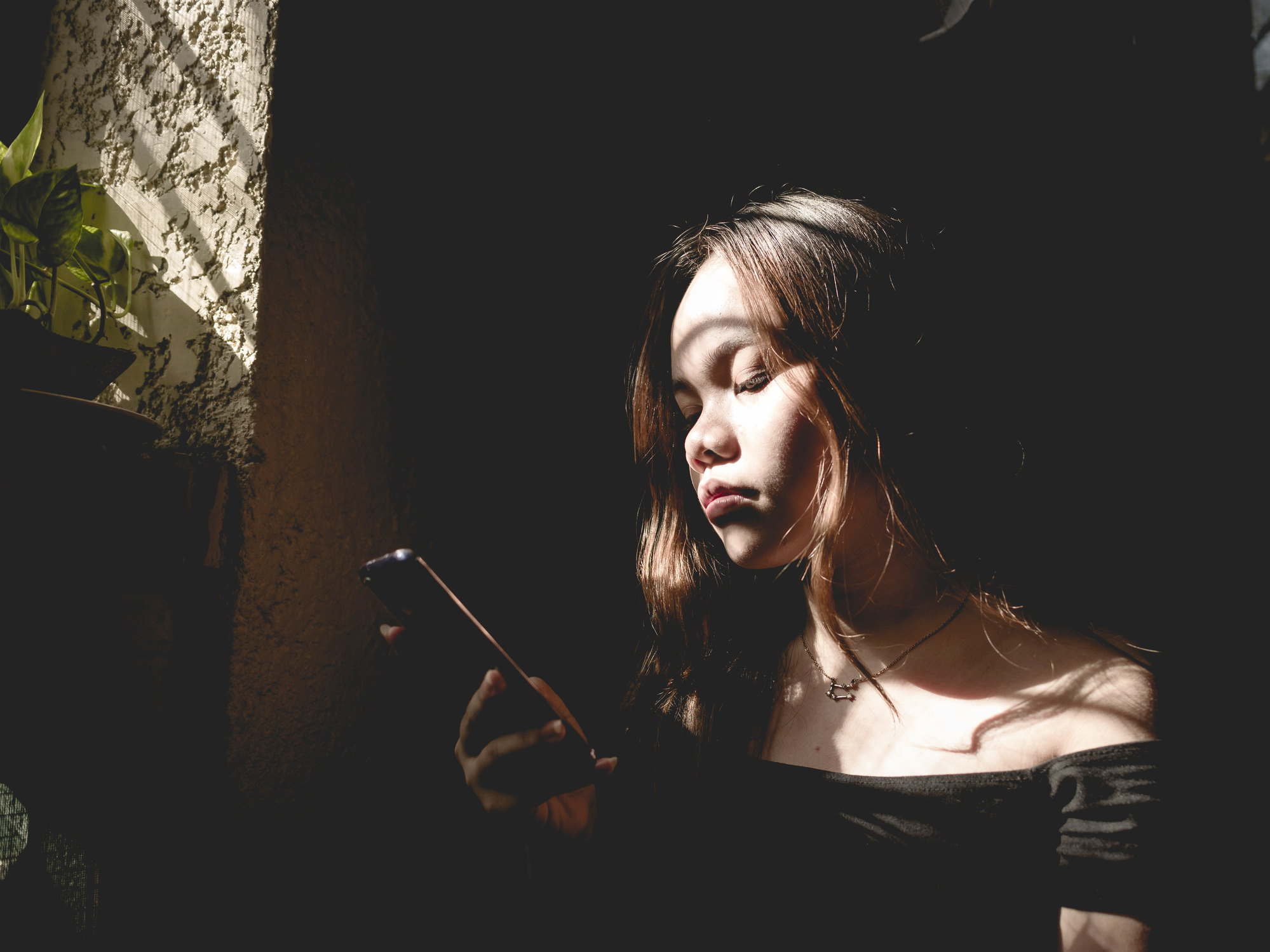 Woman looking at smartphone and her expression is contemplative