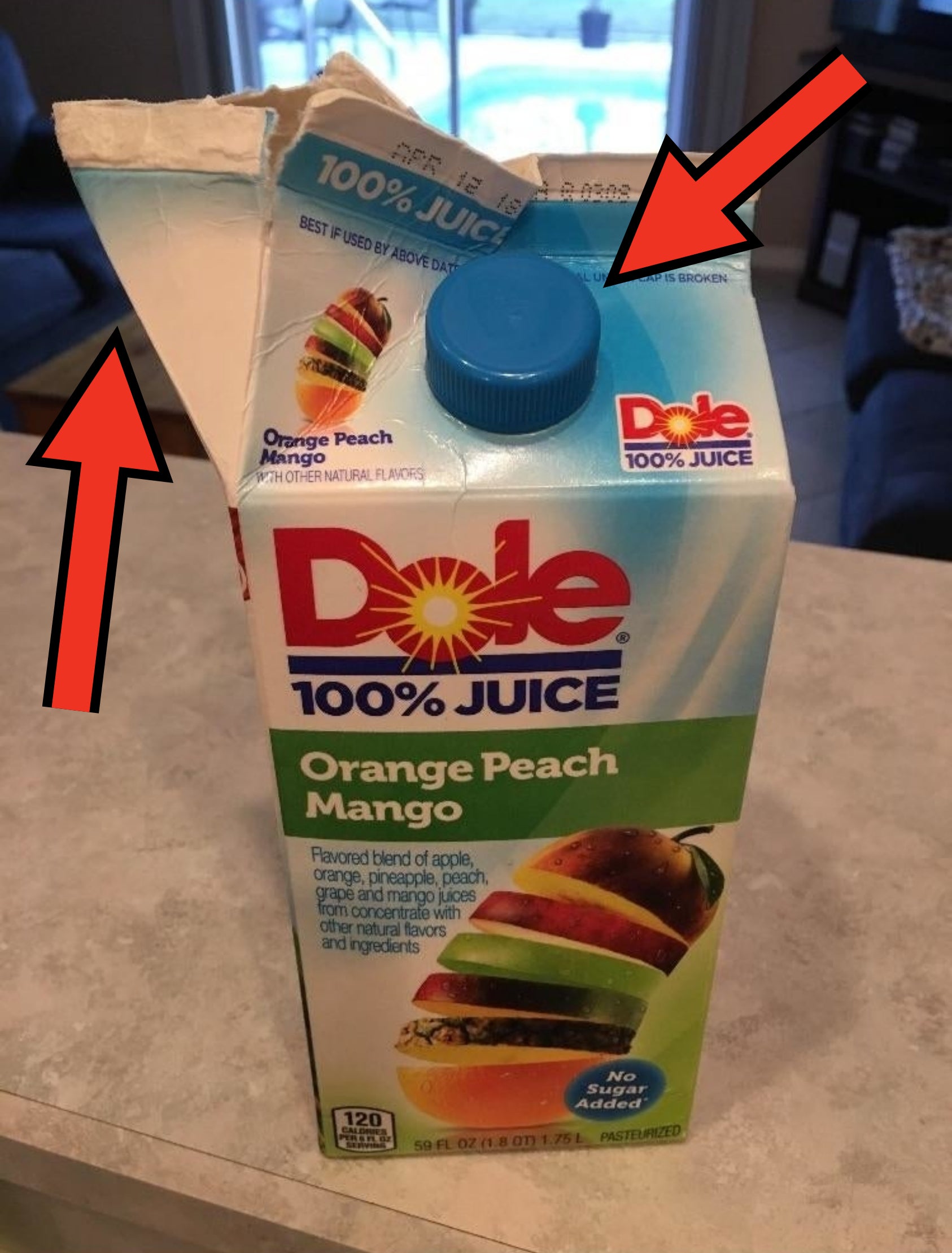 Carton of Dole 100% Juice with Orange Peach Mango flavor that has been opened incorrectly from the side