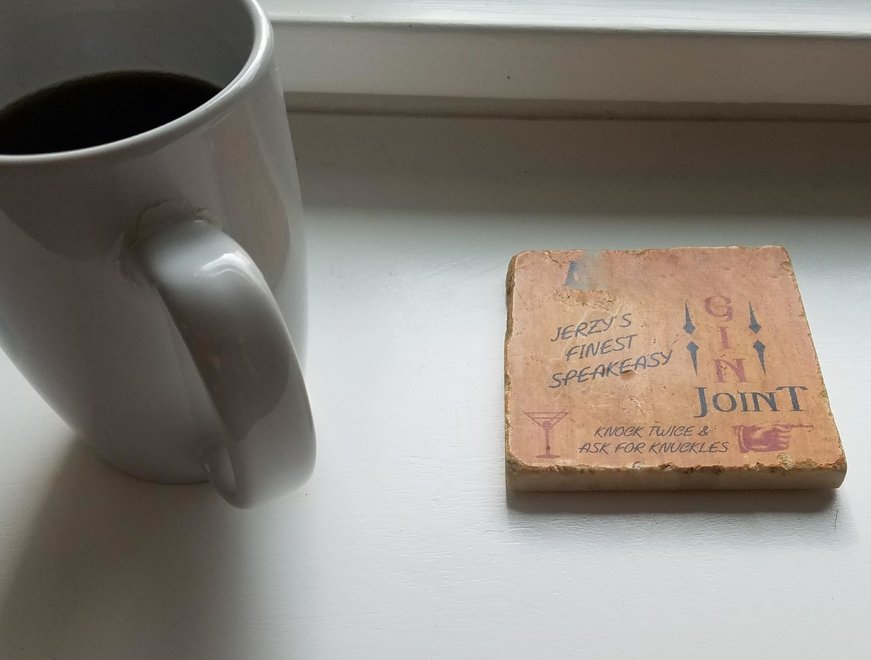 A mug next to two coasters with text; one says &quot;Jerry&#x27;s Finest Speakeasy&quot; and the other mentions &quot;Benjamin&#x27;s Finest Speakeasy.&quot;