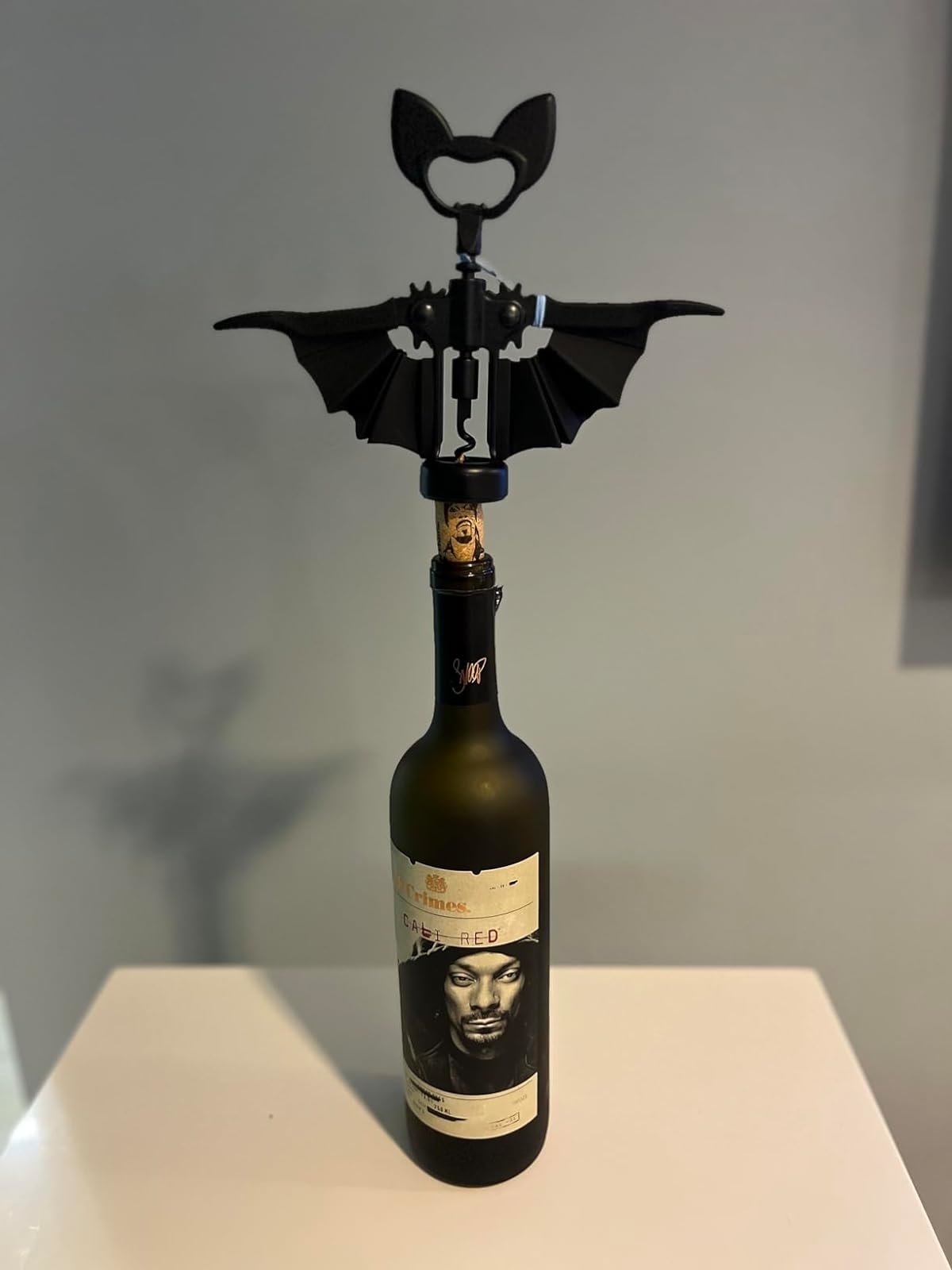 A bat-shaped wine opener on a wine bottle
