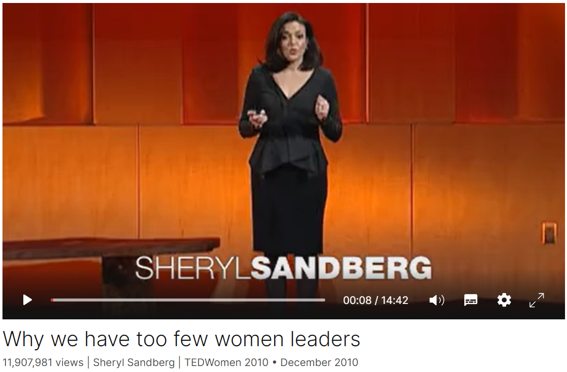 Sheryl Sandberg giving a TED Talk on women leaders, standing on stage with a presentation screen behind her