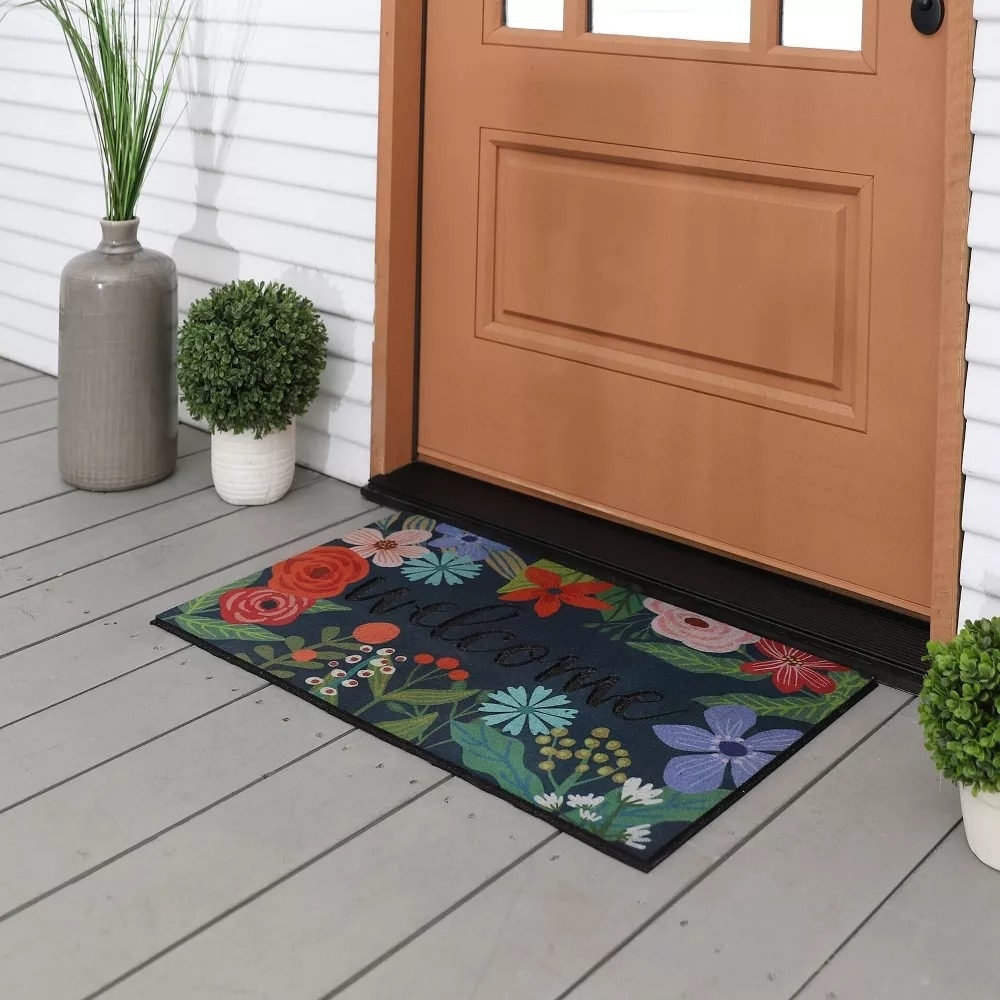 Floral welcome mat in front of a door