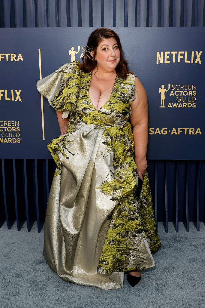 Ashlie Atkinson in a long patterned gown with ruffled details around one shoulder and down one leg