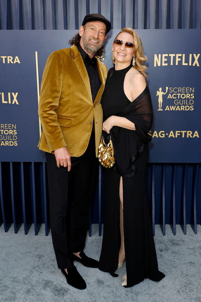Troy Kotsur  wears a velvet blazer and Deanne Bray is in a long dress with a slit,