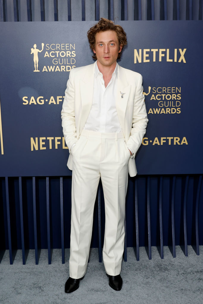 Jeremy Allen White in a stylish white suit with black shoes
