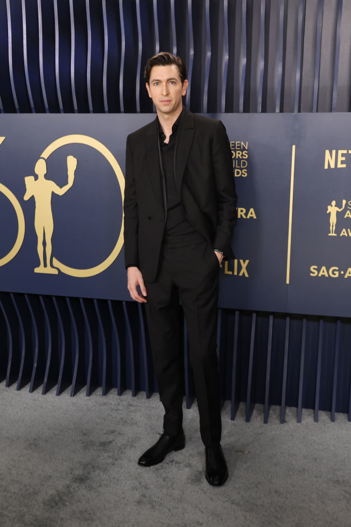 Nicholas Braun in a suit and dress shoes