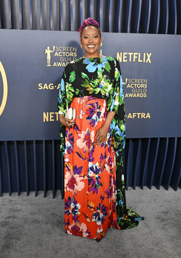 Erika Alexander wearing a bright floral dress with flowy sleeves