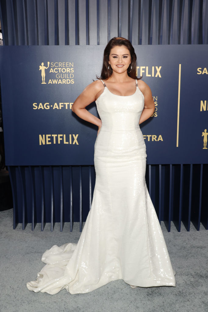Selena Gomez in an elegant white gown with a trailing hem