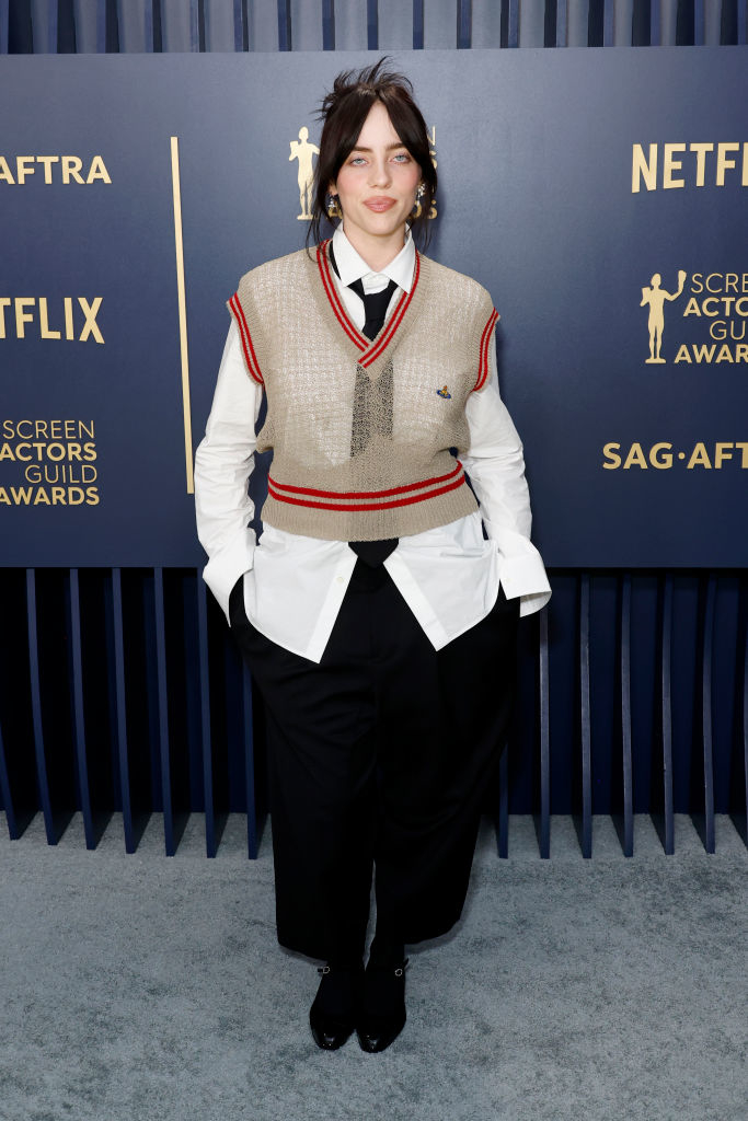 Billie Eilish wearing a vest, shirt, and tie with trousers