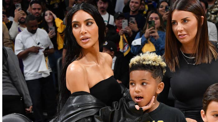 Kim Kardashian and son Saint West at a sports event, both watching intently. She&#x27;s in a black outfit, he&#x27;s in a black and yellow shirt