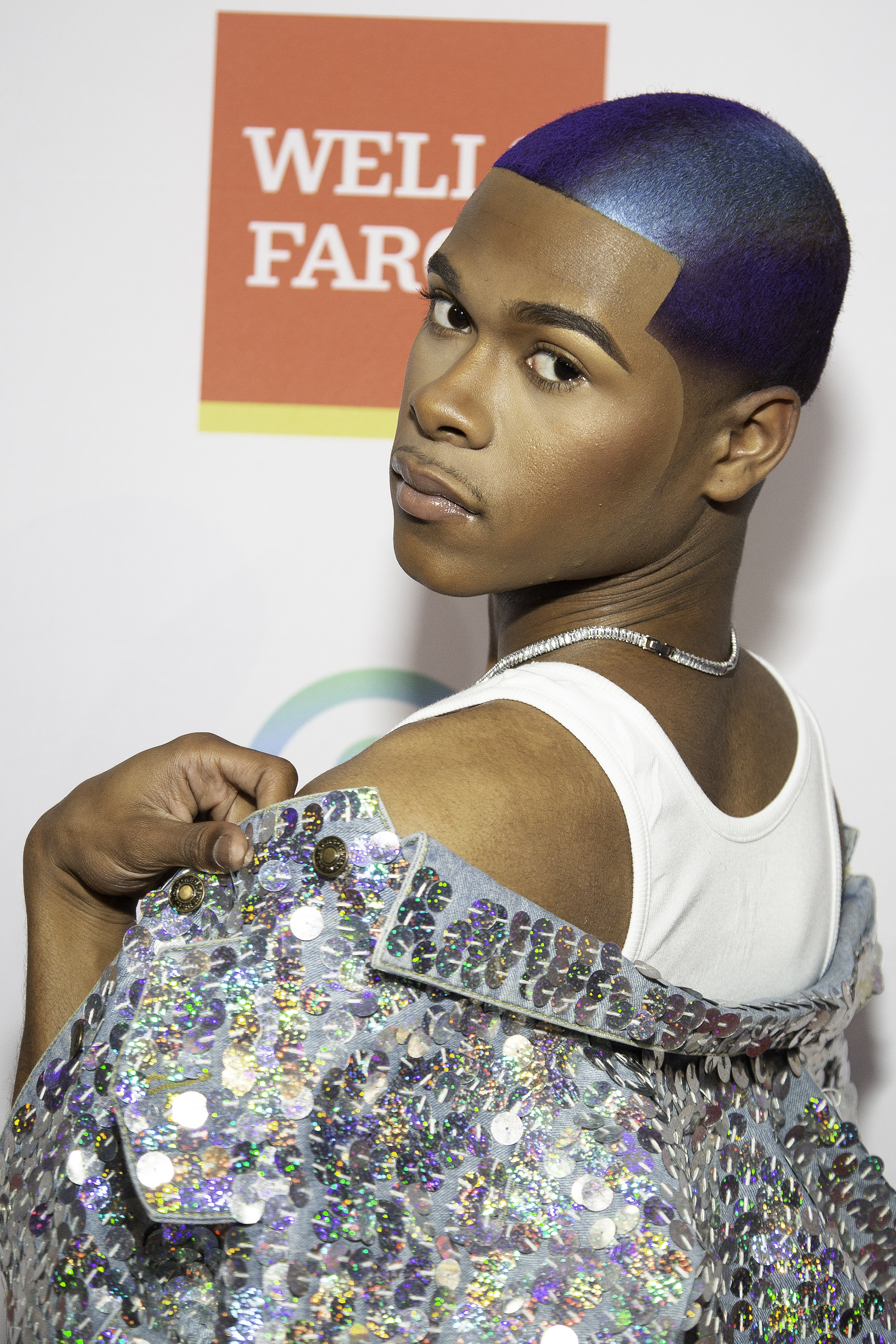 Kidd Kenn posing with a sequined outfit and a blue-toned hairstyle