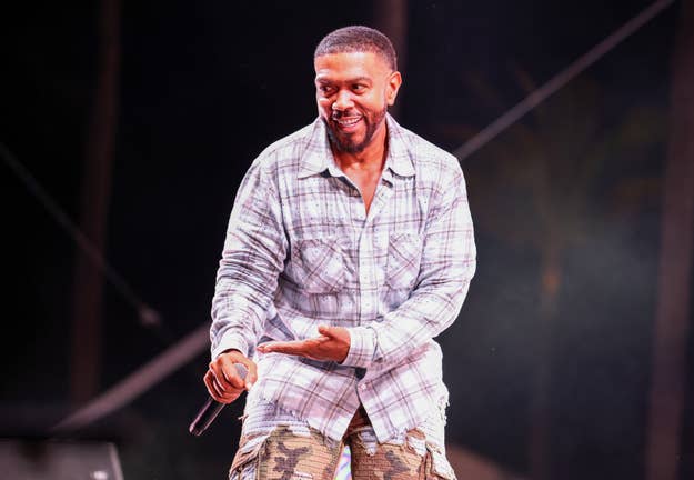 Timbaland performing on stage in a plaid shirt and camo pants
