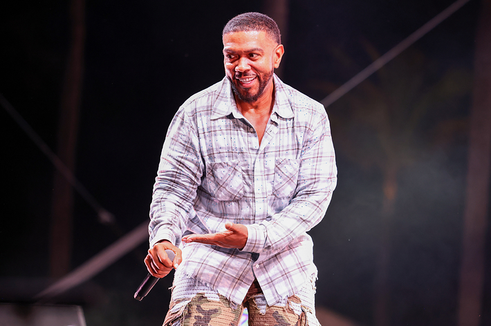Timbaland performing on stage in a plaid shirt and camo pants