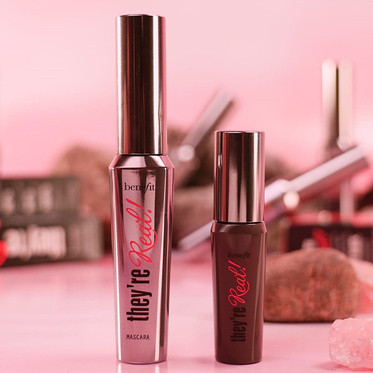Two Benefit &quot;They&#x27;re Real!&quot; mascaras on a pink background