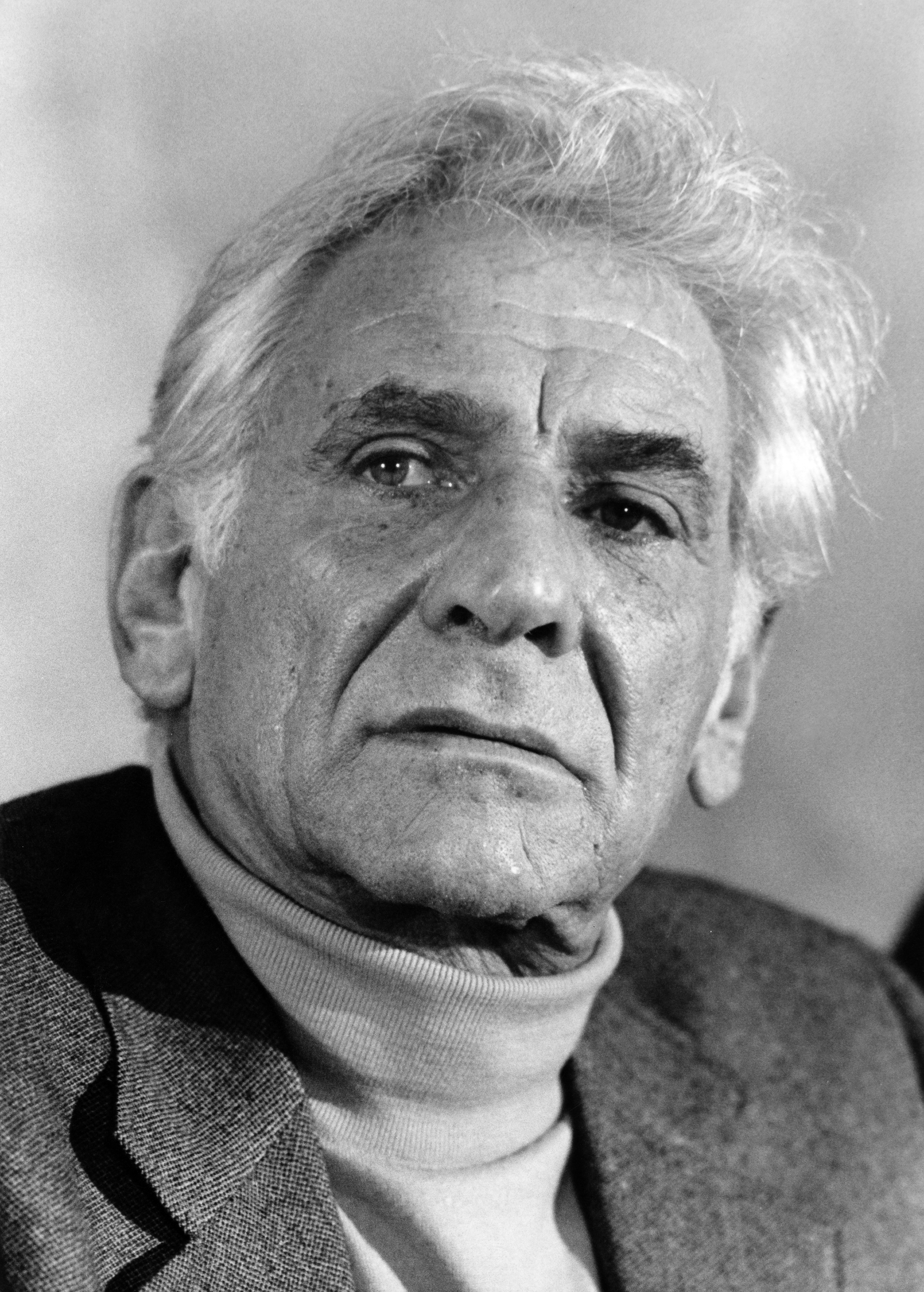 Close-up of Leonard Bernstein in a turtleneck and jacket, expressing thoughtfulness