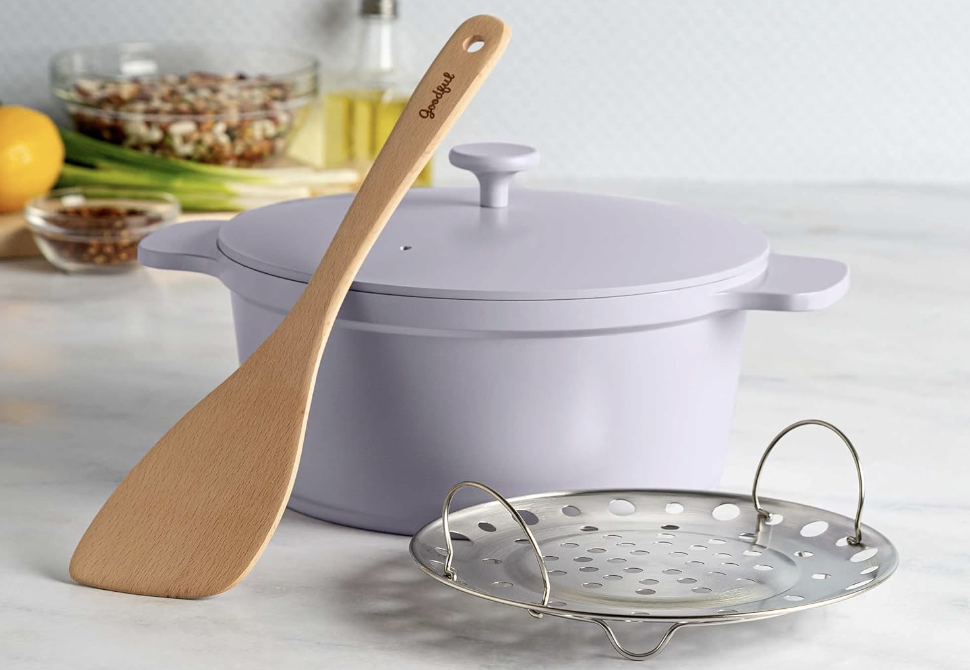 purple Dutch oven with steaming basket and wood spoon