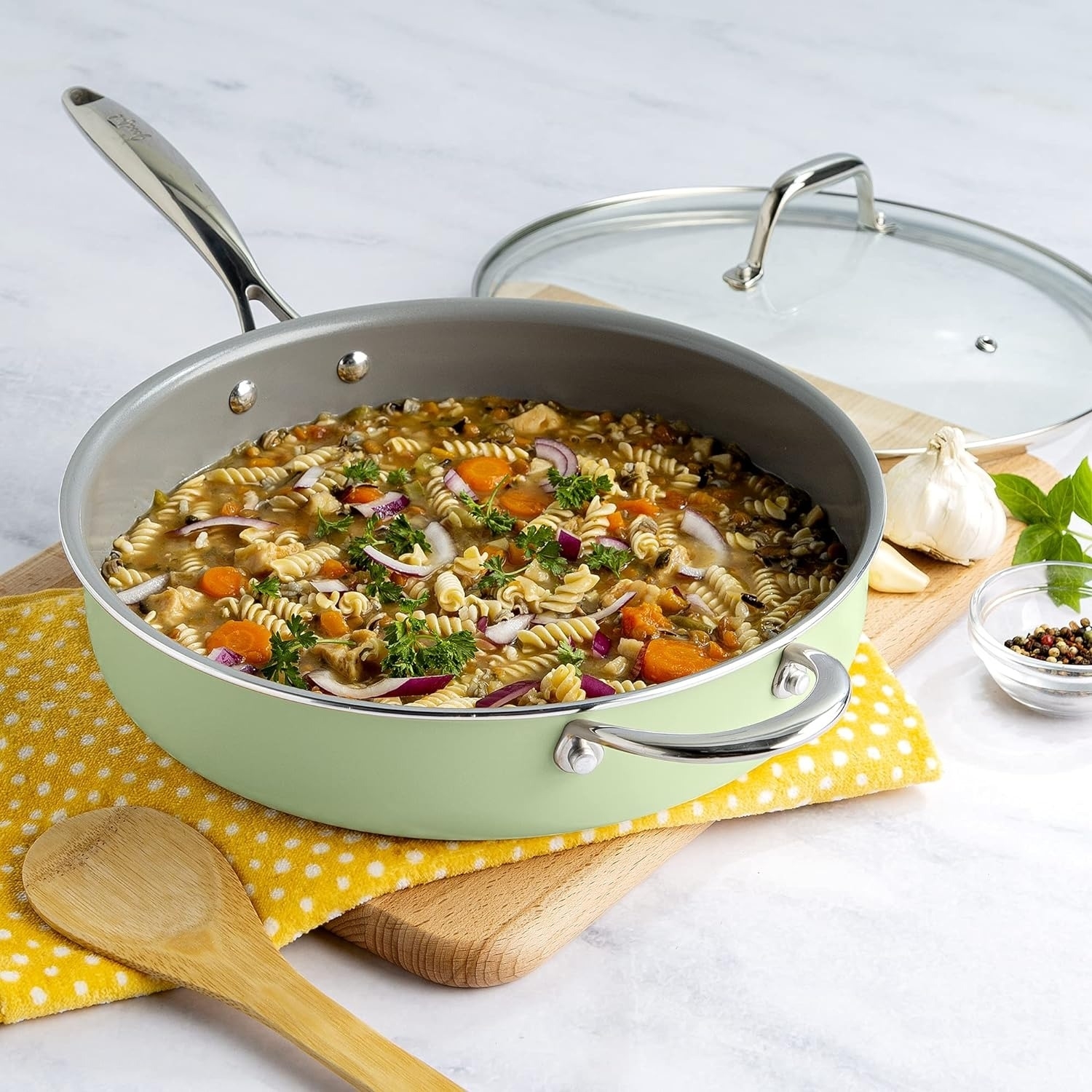green ceramic nonstick saute pan with veggie pasta soup inside
