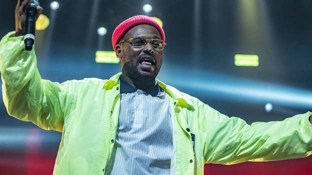 Schoolboy Q on stage wearing a neon jacket and red beanie.