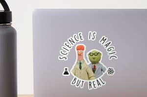 Laptop with a sticker of the Muppets' Beaker and Dr. Bunsen with text "Science is magic but real."