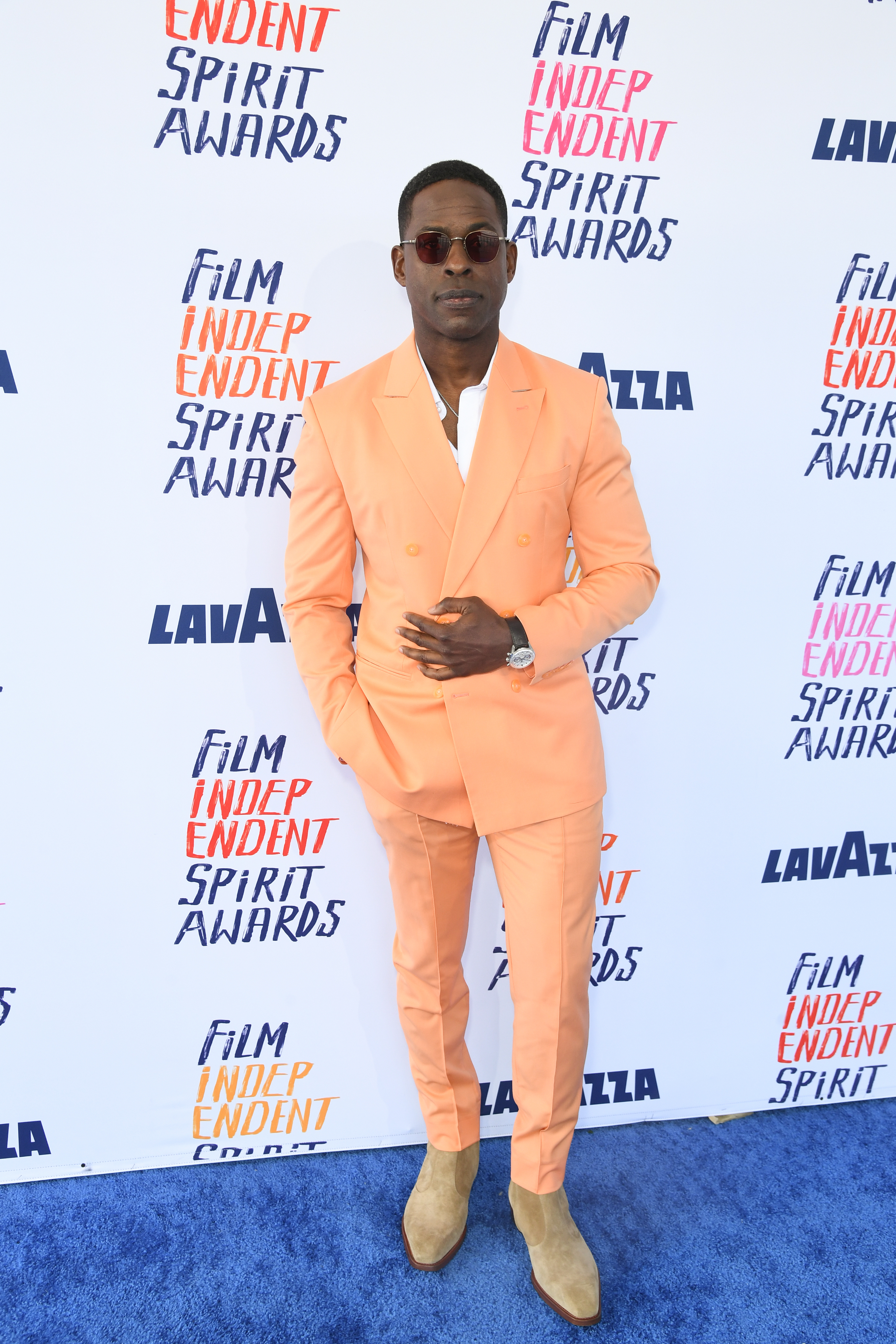 Sterling in pastel suit and sunglasses posing at Film Independent Spirit Awards